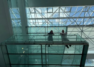 Photo of Jagoda Cupac and Christian Louter looking down from a glass balcony.